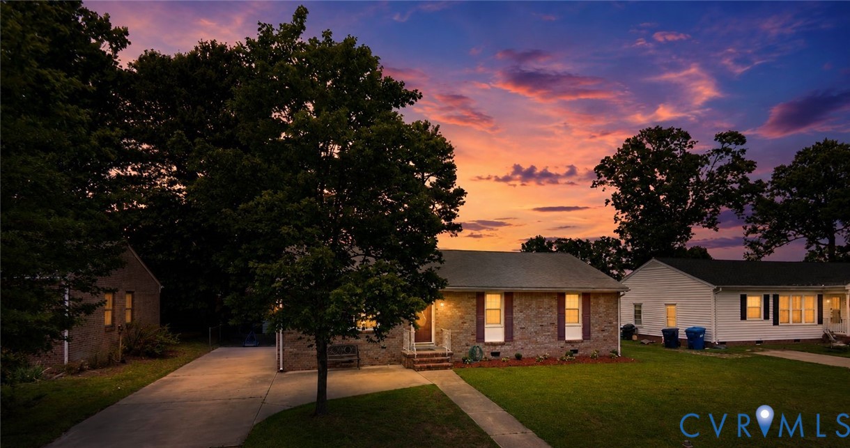 Brick-front residence featuring a classic facade with white trim and dark shutters
