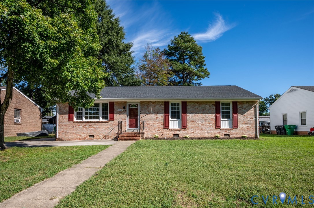 Brick exterior featuring a dark-toned roof, red shutters, and a front entry with a red door