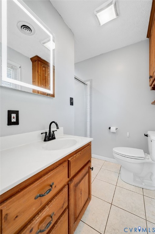 Wood-finish vanity with a white countertop and basin sink, matte black faucet, illuminated mirror, and tiled flooring