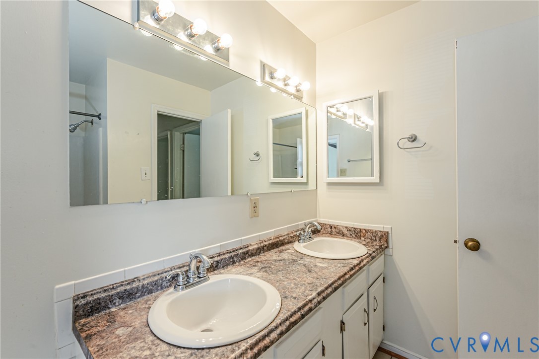 Dual undermount sinks set within a granite-look countertop with an integrated backsplash