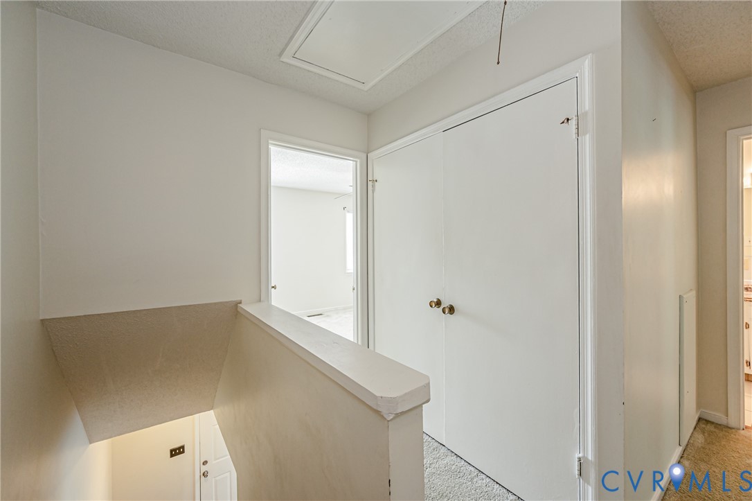 Interior hallway featuring light-colored walls and carpeting
