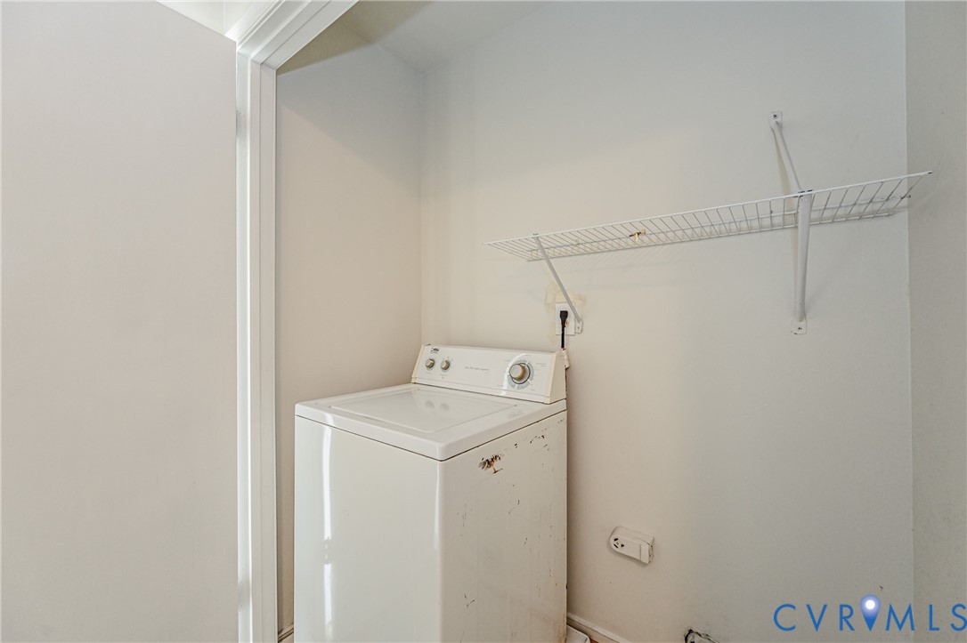 Utility area featuring a top-load washing machine, white wire shelving, and neutral wall tones