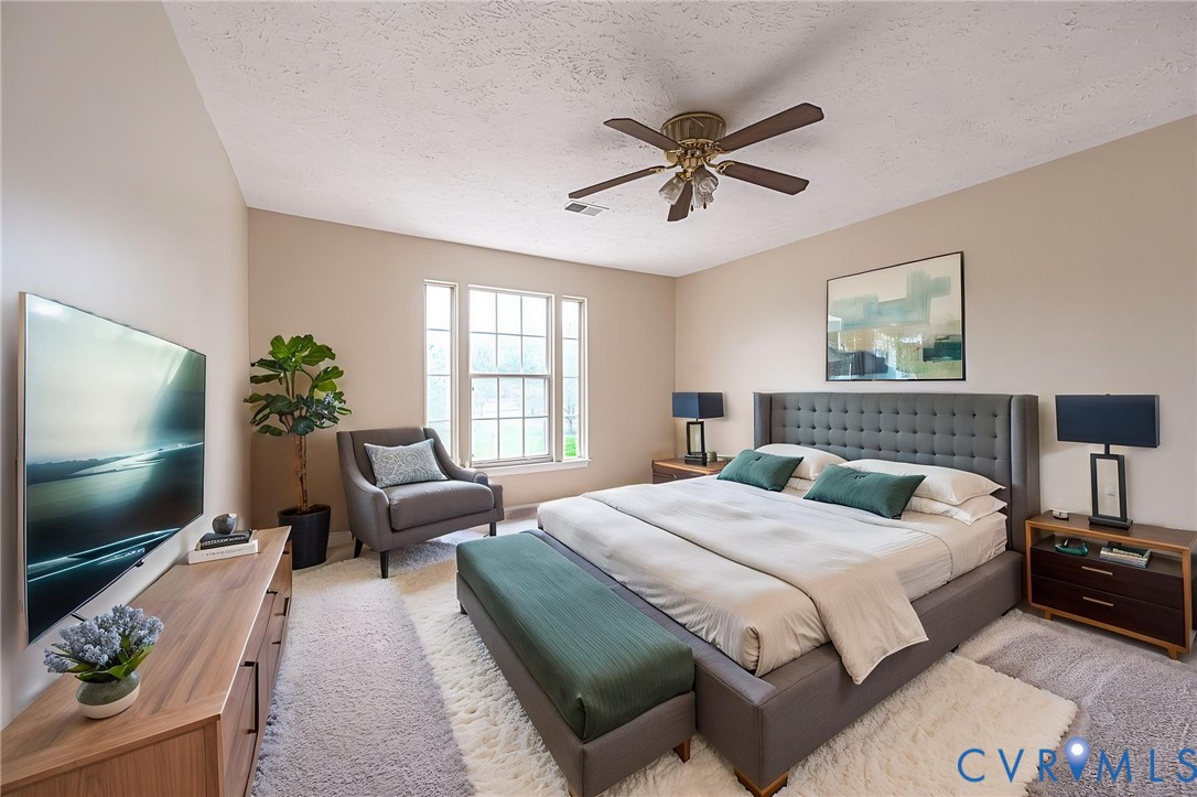 Spacious room with a vaulted ceiling, abundant natural light from multiple windows, and a ceiling fan light fixture~ Virtually Staged