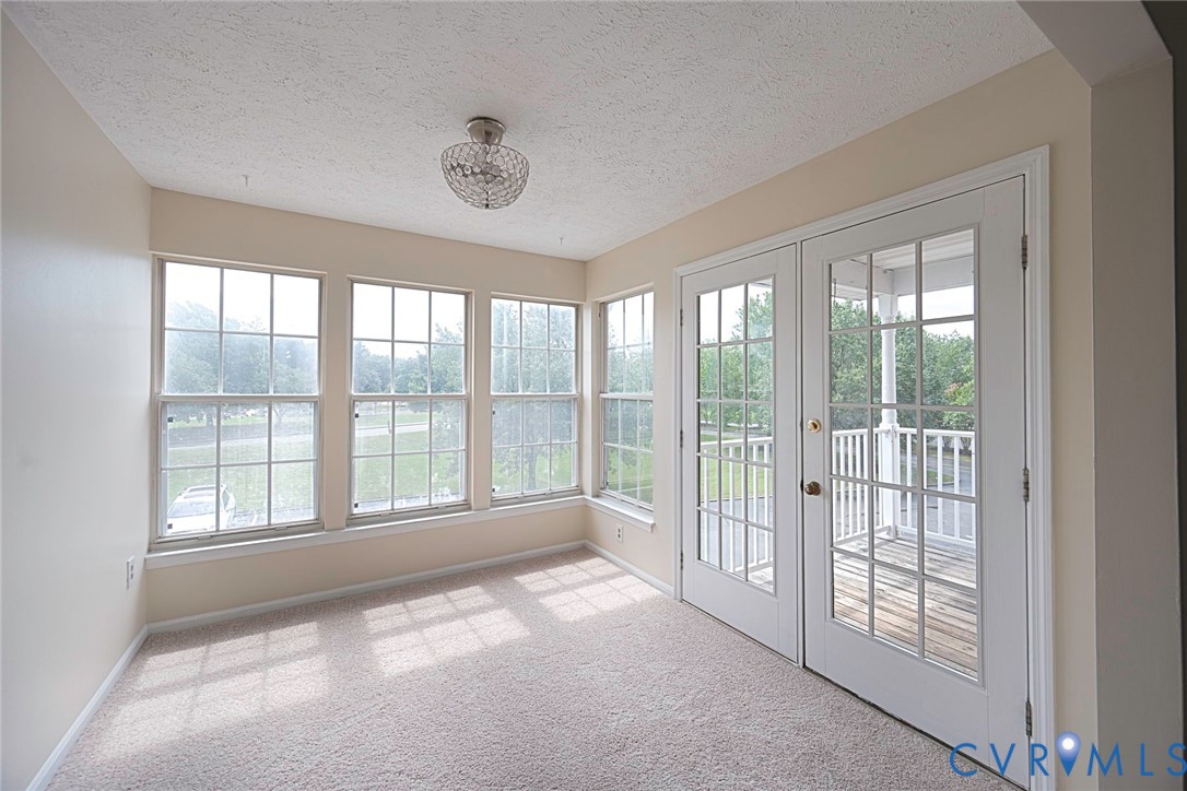 Room featuring plush carpeting and a flush-mount crystal light fixture