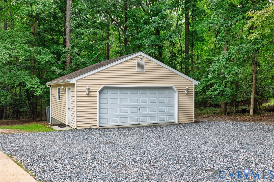 Detached garage with horizontal vinyl siding and a single panel garage door Detached garage with horizontal vinyl siding and a single panel garage door