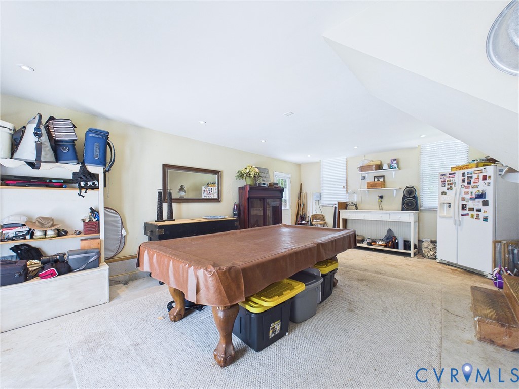 Spacious room featuring light-toned carpeting and a partial sloped ceiling