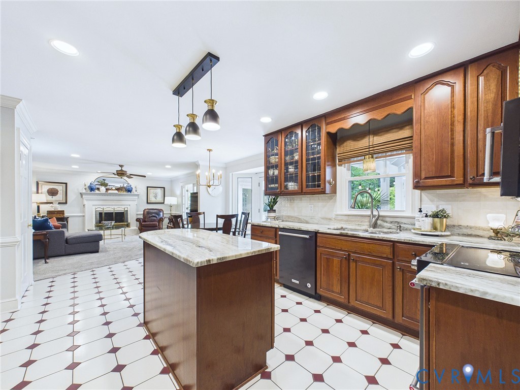 Kitchen featuring wood cabinetry, light-toned stone countertops, and a tile floor with geometric accents