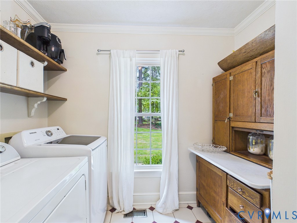 Laundry area featuring wood-finish shelving, a multi-pane window, and a built-in wood-finish hutch with a countertop
