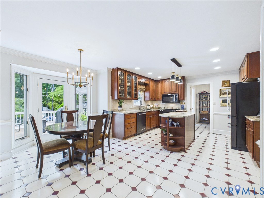 Eat-in kitchen featuring patterned tile flooring, wood cabinetry with glass accents, light granite countertops, and a central island with integrated shelving