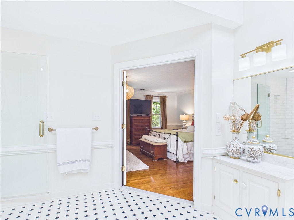 Bathroom featuring a white vanity with a light-colored countertop and a gold-finished light fixture