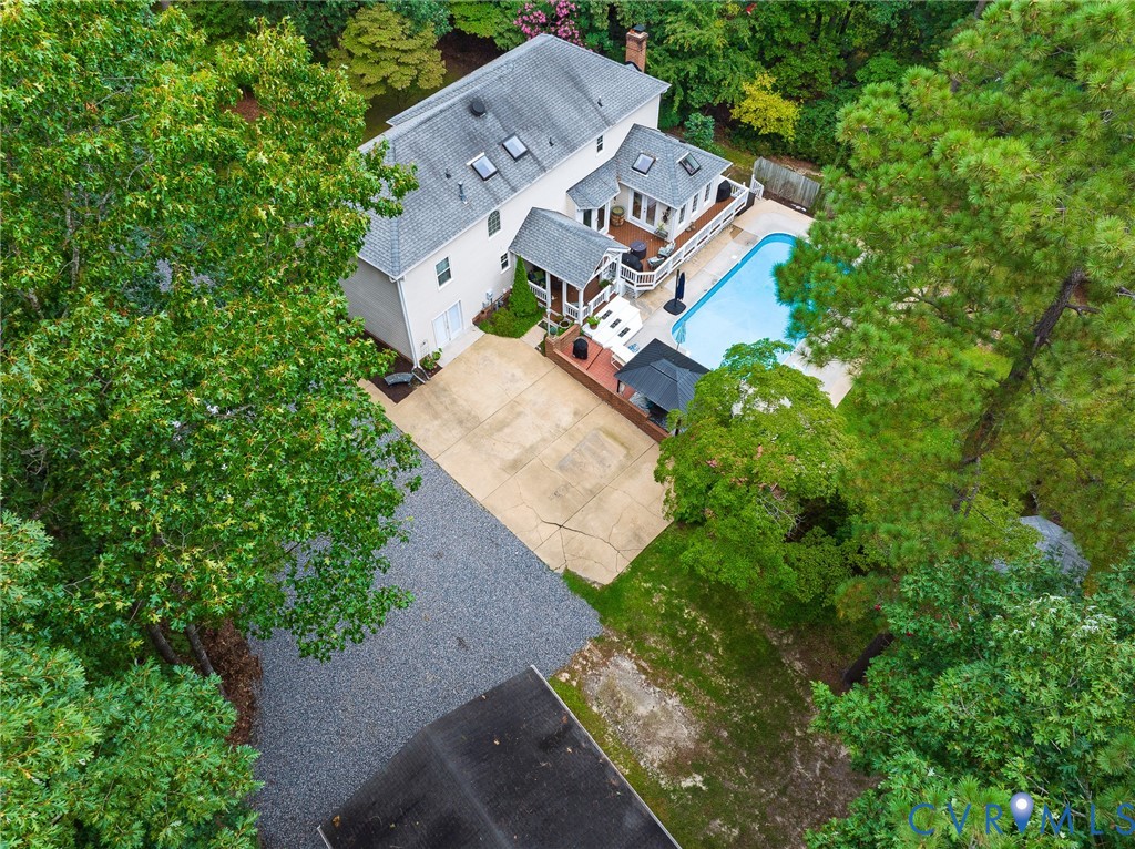 Expansive backyard featuring a rectangular swimming pool, multiple outdoor deck areas, and a covered patio structure
