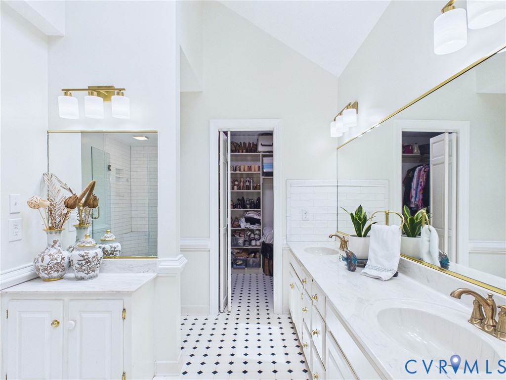 Dual vanity with integrated sinks, brass-finish fixtures, and a large wall mirror