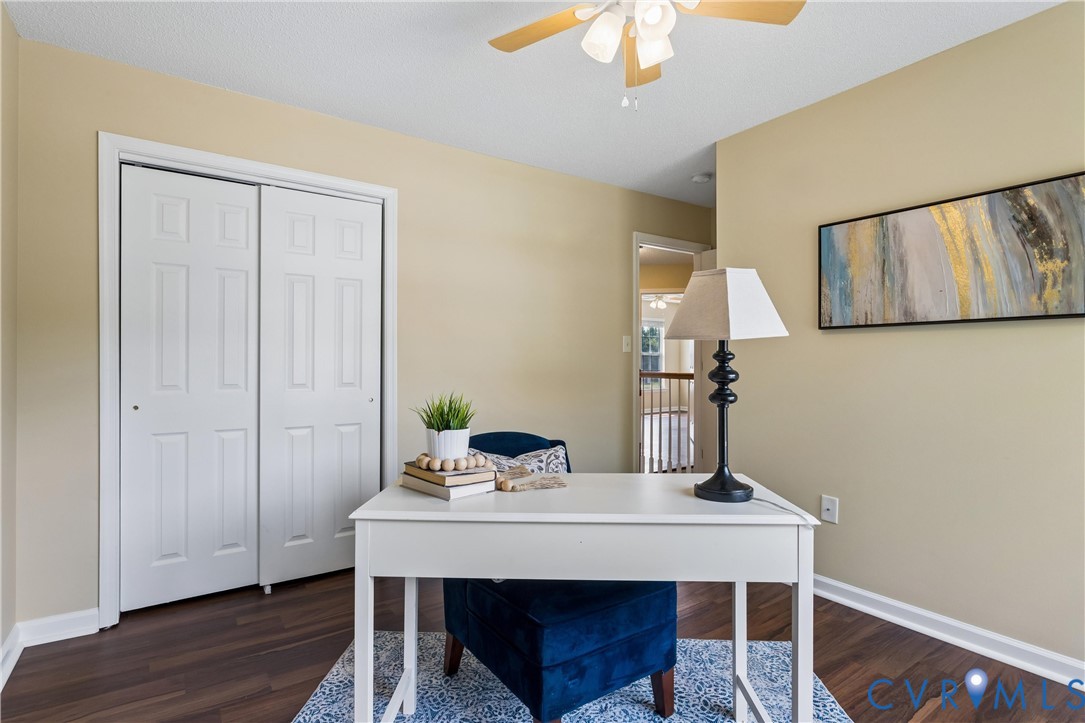 Room featuring wood-finish flooring, a ceiling fan with integrated lighting, and a white bi-fold closet
