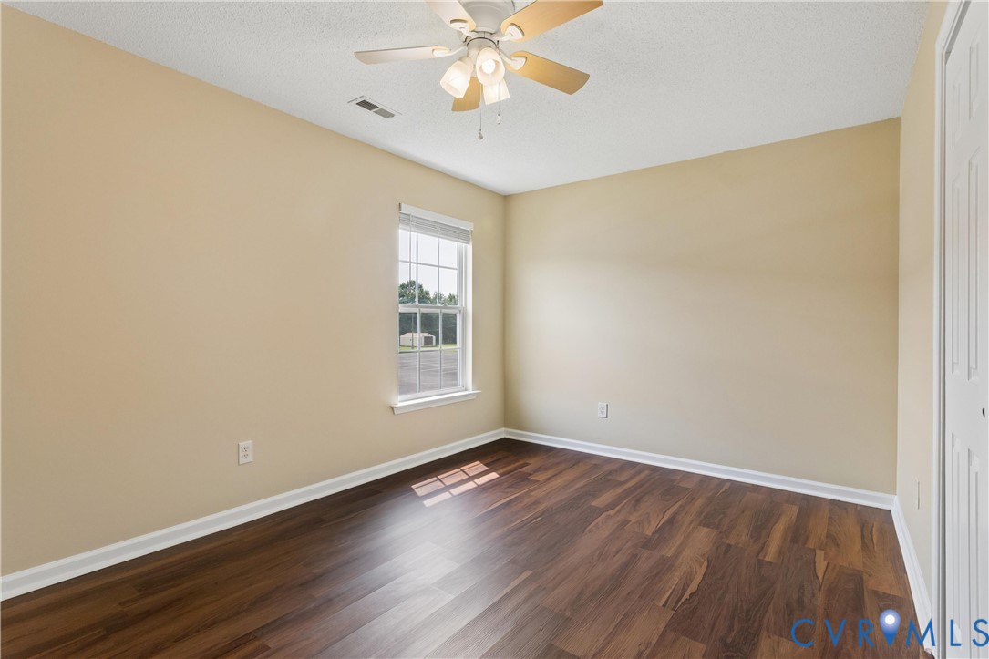 Room featuring wood-finish flooring, neutral wall paint, and white trim