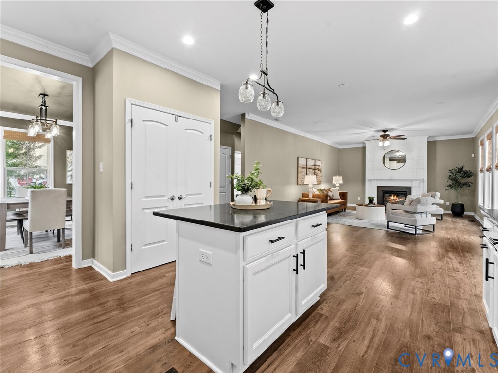Kitchen island featuring white cabinetry with dark hardware and a contrasting dark countertop