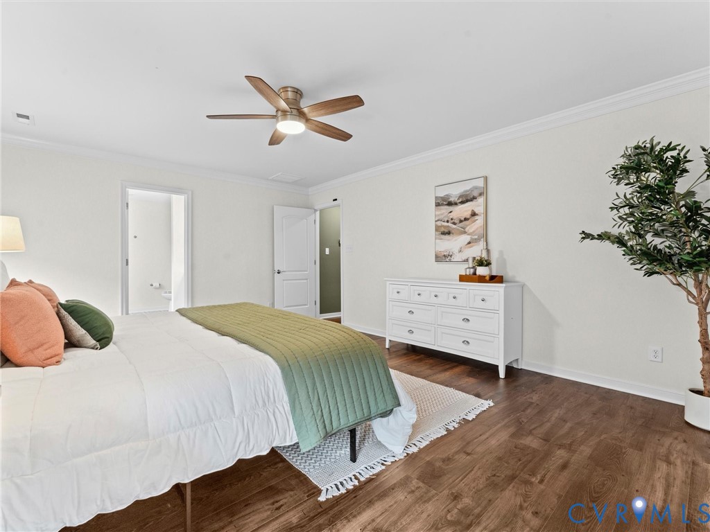 Spacious room featuring wood-finish flooring, white walls, and a ceiling fan with integrated lighting