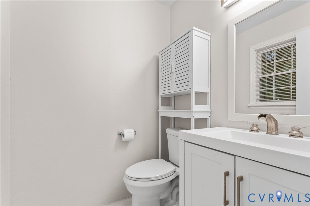 Bathroom vanity with integrated sink, brushed nickel faucet, and a framed mirror