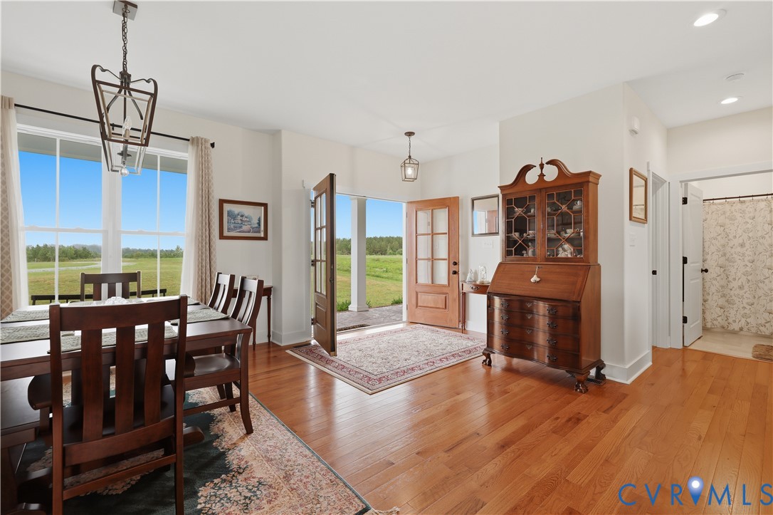 Hardwood flooring extends throughout the entry and dining area