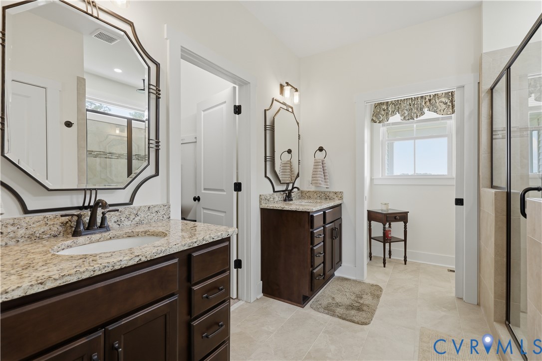 Double vanity bathroom featuring granite countertops and dark wood cabinetry