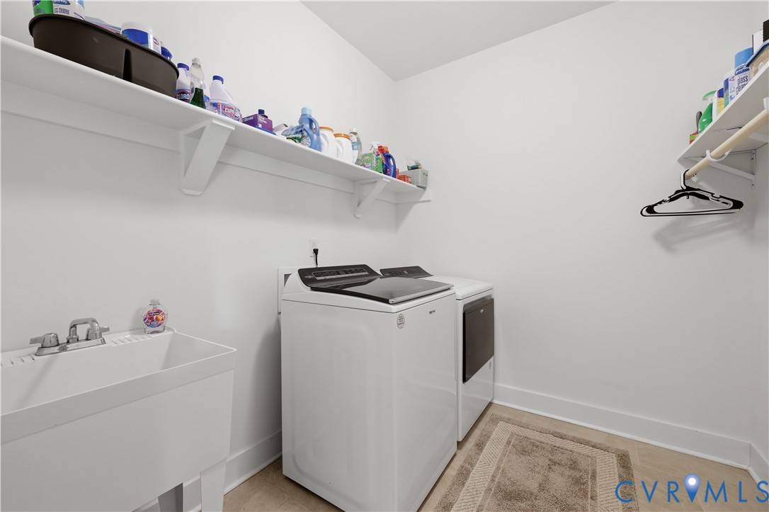 Dedicated utility space featuring a utility sink with dual-handle faucet, expansive shelving, and a hanging rod