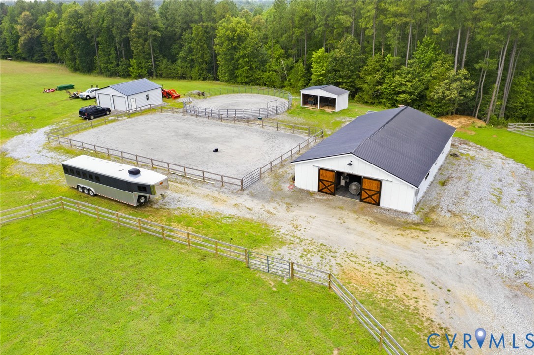 White barn with a dark metal roof, featuring large wood-finish sliding doors