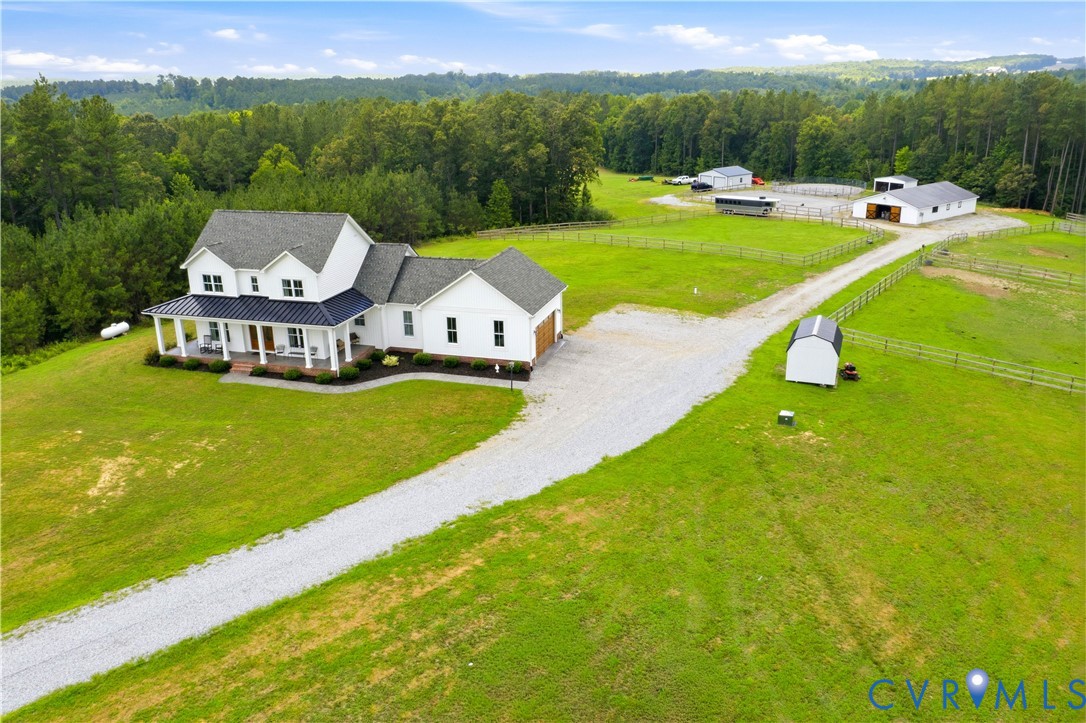 Expansive property featuring a white two-story residence with a covered porch and attached garage