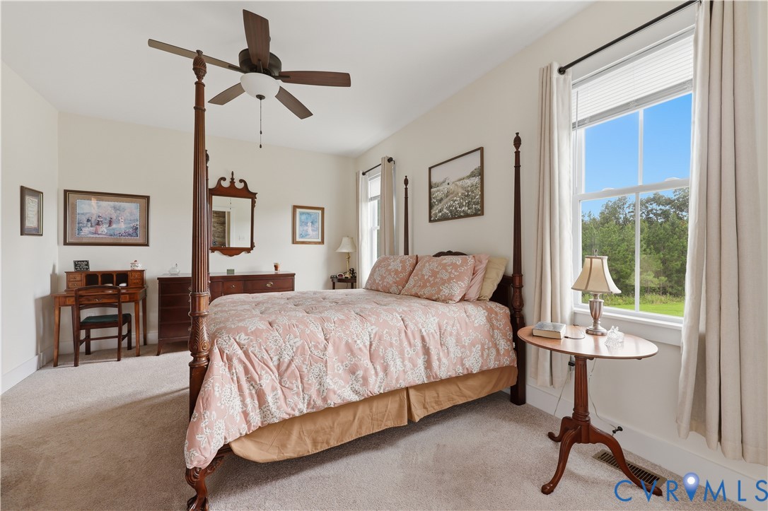 Spacious room featuring neutral carpeting, light-toned walls, and a ceiling fan with integrated lighting