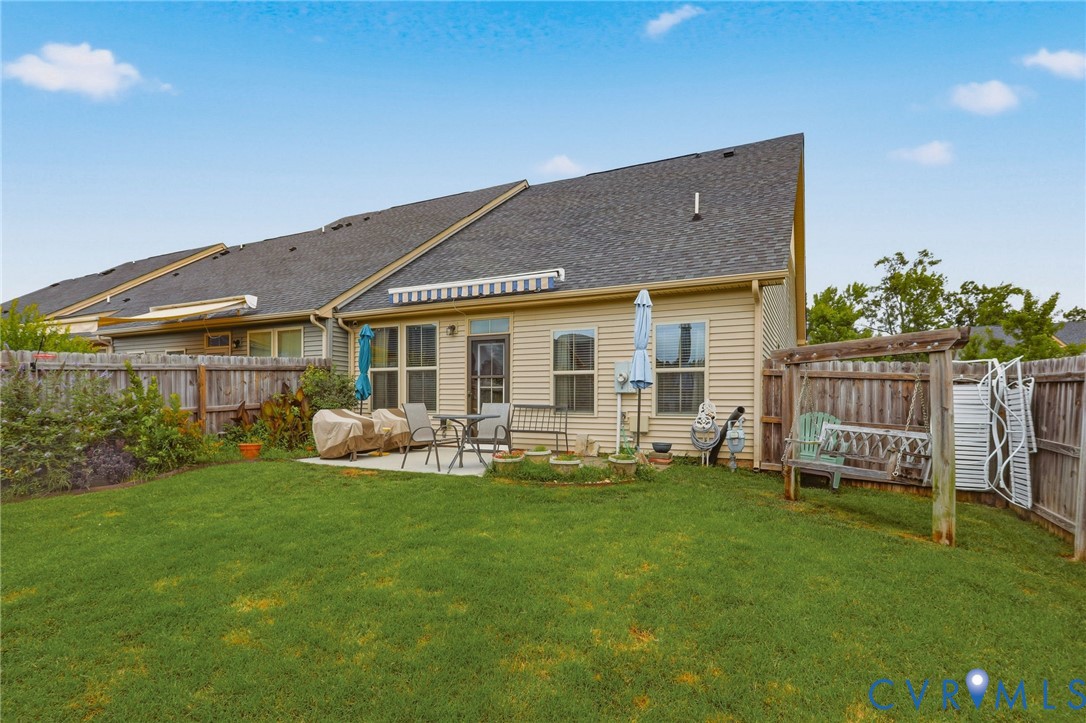 Private backyard featuring a concrete patio, wood fencing, and a pergola structure