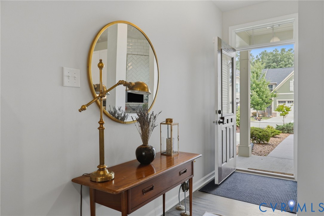 Entryway featuring a solid panel door, transom window, and light wood-finish flooring
