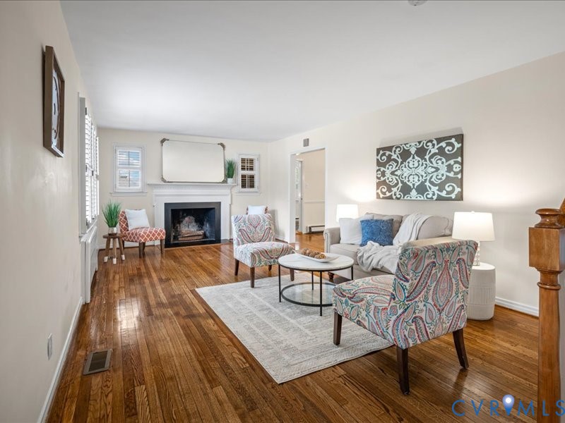Spacious Living Room with wood burning fireplace and refinished hardwood floors.