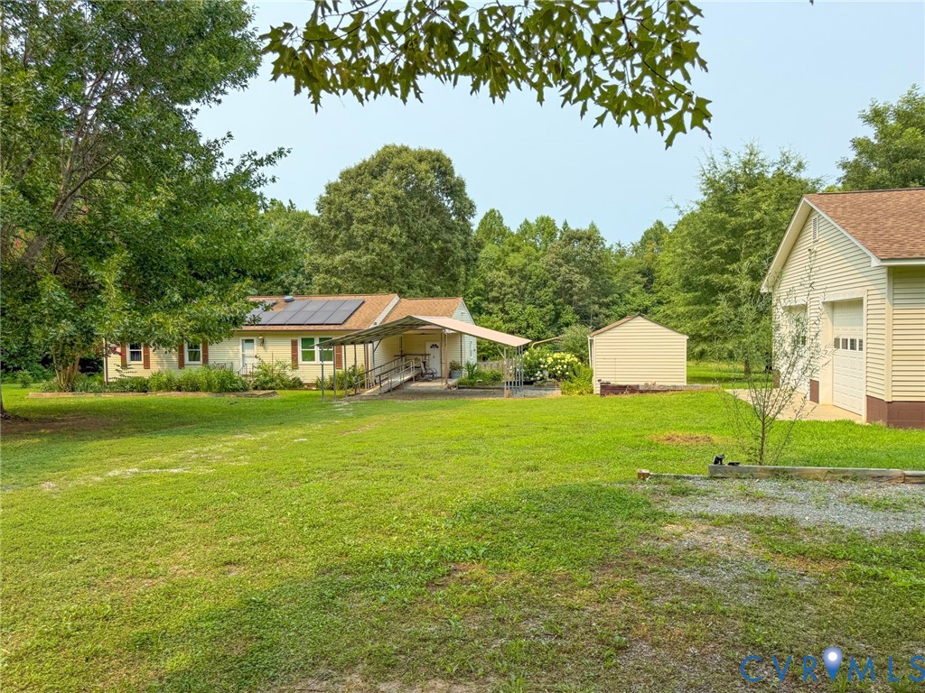Expansive outdoor space featuring a detached two-car garage, a separate storage shed, and mature tree landscaping Expansive outdoor space featuring a detached two-car garage, a separate storage shed, and mature tree landscaping