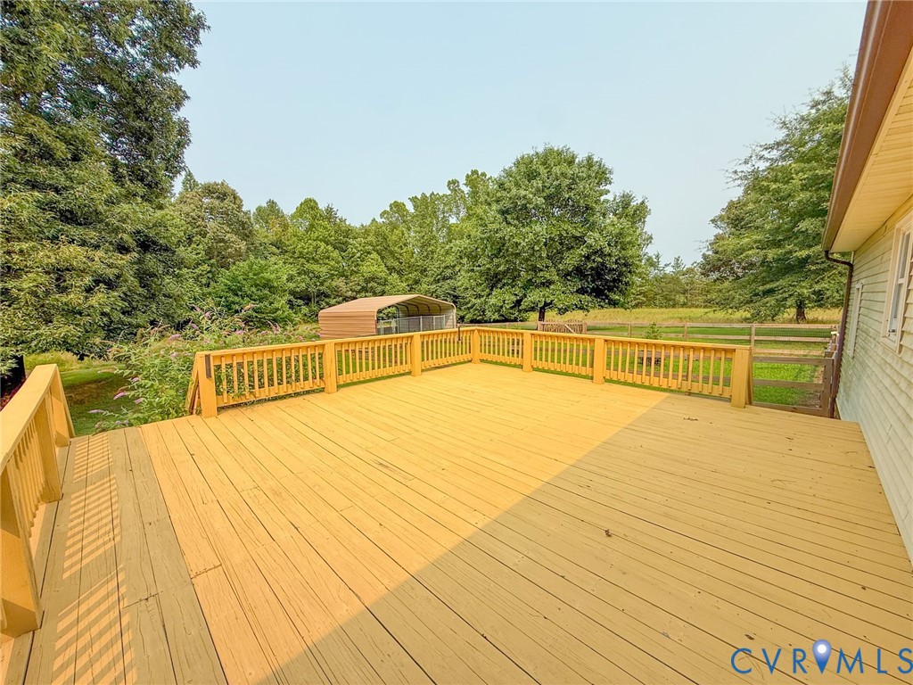 Expansive outdoor deck featuring wood-finish flooring and a wood railing