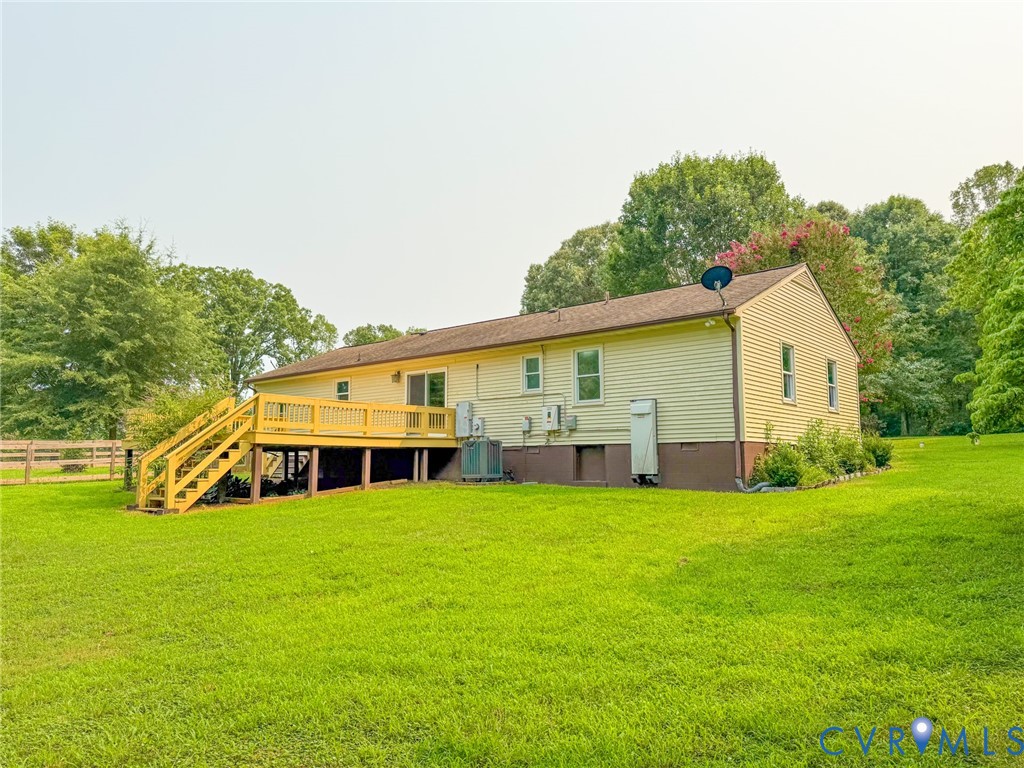 Exterior siding with a spacious rear deck featuring wood railing and stairs