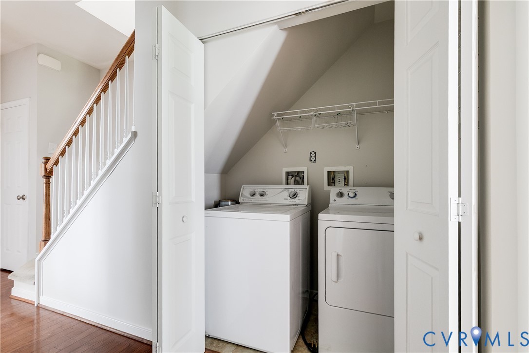 Dedicated laundry area featuring a washer and dryer, wire shelving, and bi-fold doors