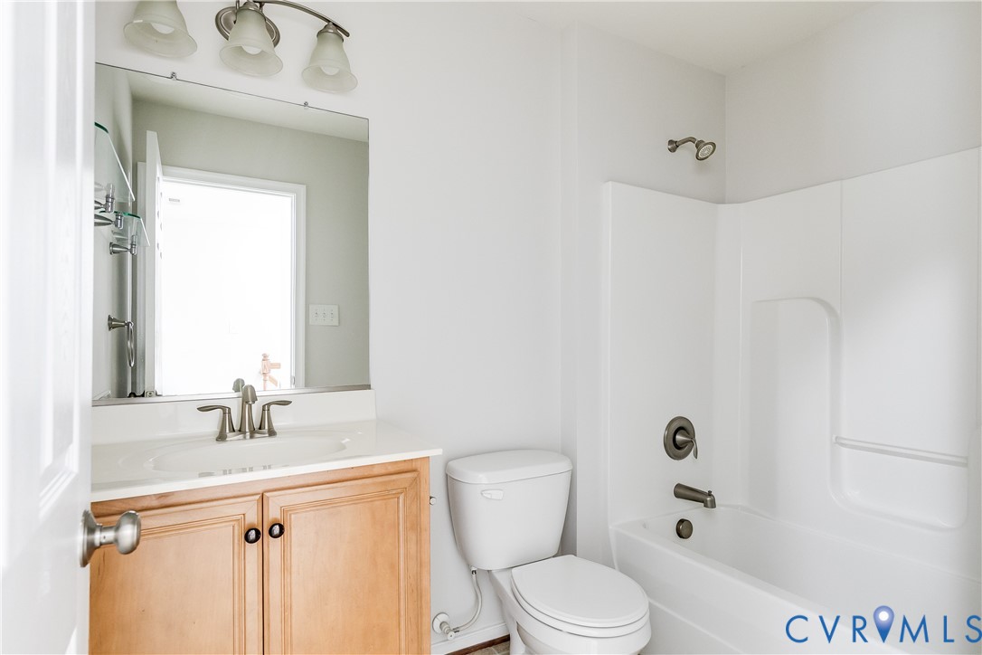 Bathroom featuring a vanity with light wood cabinetry, white countertop, and brushed nickel fixtures