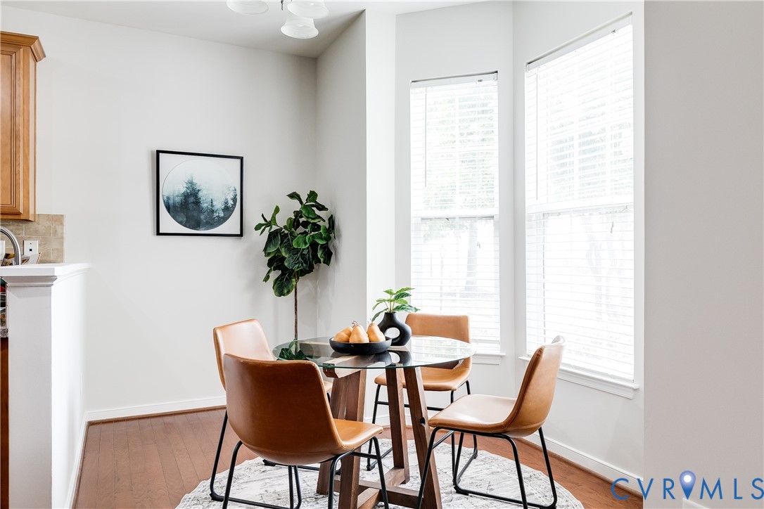 Dining area featuring wood-finish flooring, two large windows, and an overhead light fixture