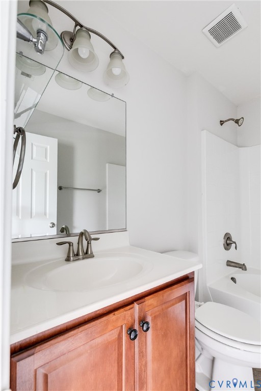 Bathroom vanity with a wood-finish base cabinet, white countertop, and integrated sink