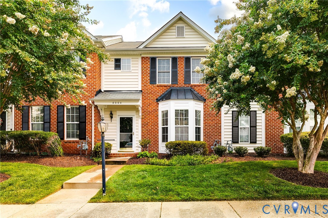 Brick-front exterior with white siding accents and a bay window