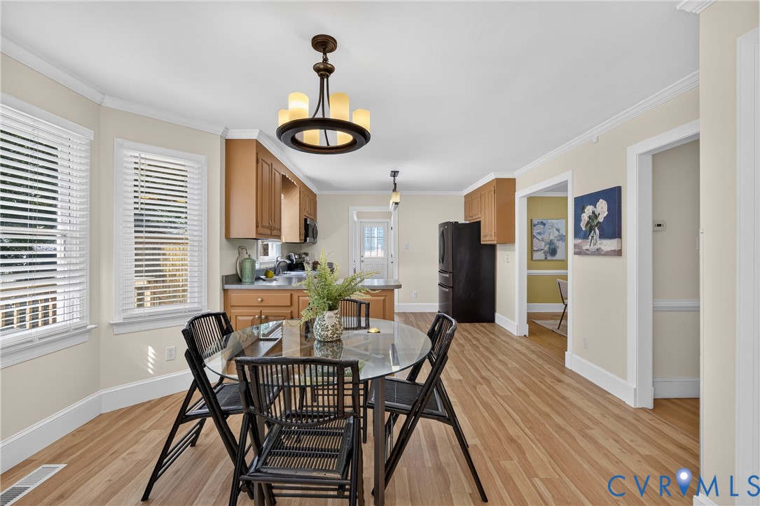 Wood-finish flooring throughout, bay windows with blinds, recessed lighting, and a kitchen featuring wood cabinetry