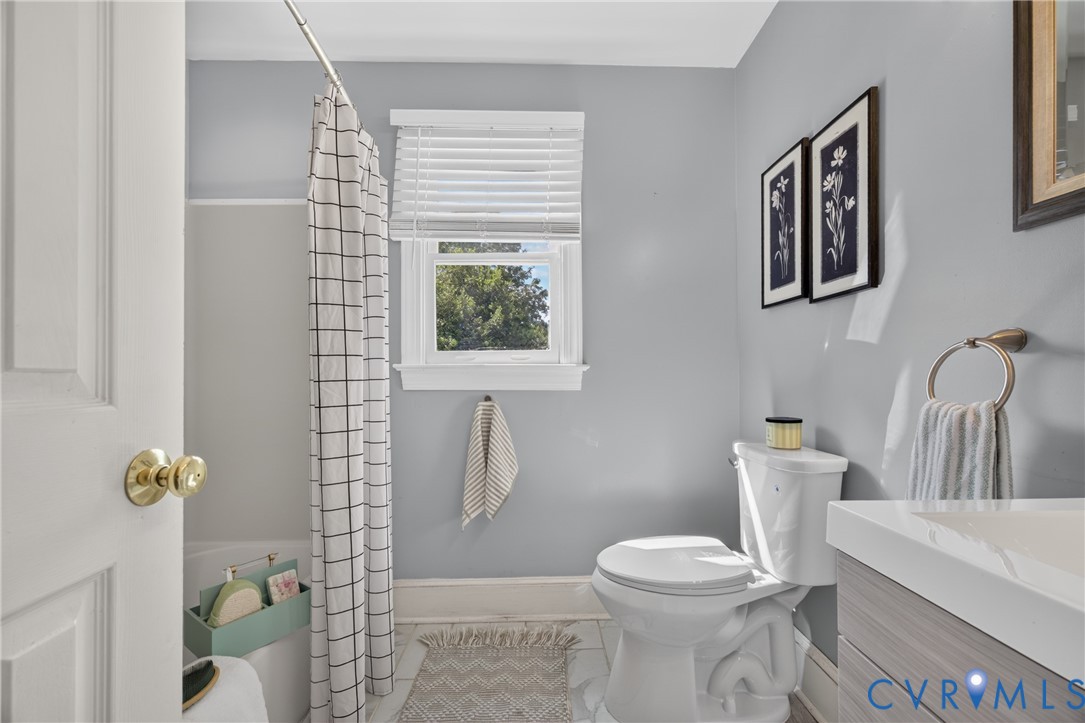 Bright, updated bathroom featuring soft gray walls, a white vessel sink with chrome fixtures, and a white toilet