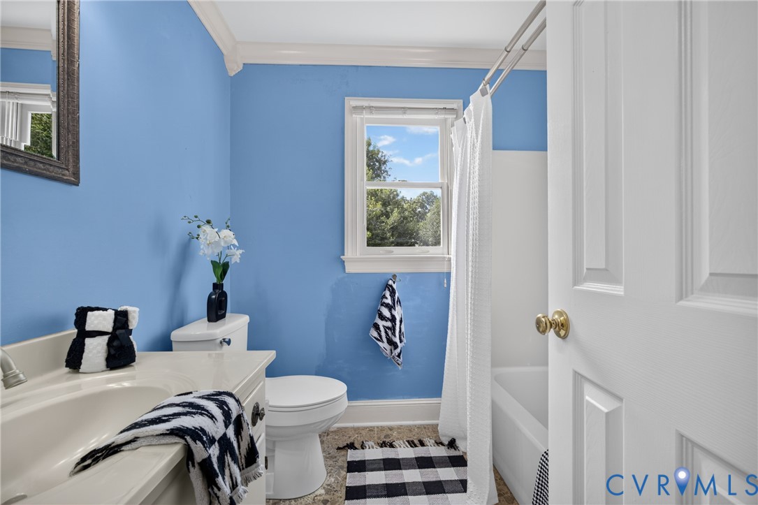 Bright bathroom featuring periwinkle-painted walls, white subway tile wainscoting, and a white ceramic pedestal sink
