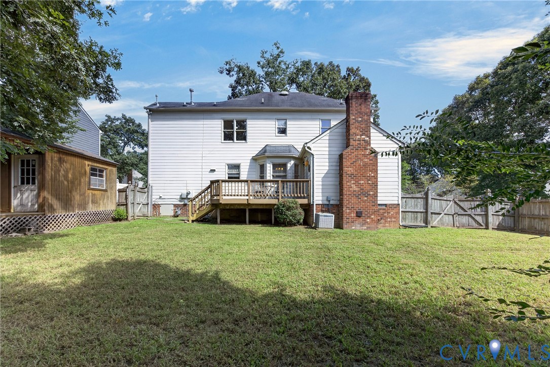 Charming two-story residence featuring white vinyl siding, a brick chimney, and a covered front porch with wooden railings