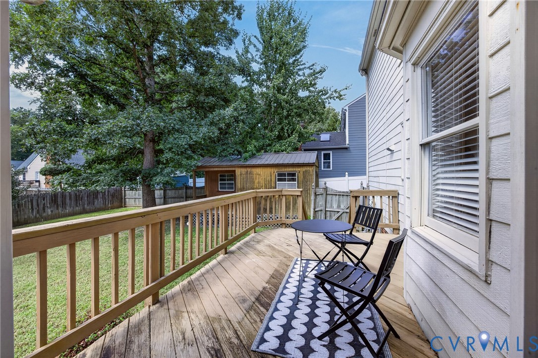 Expansive wood deck with a matching wood railing, overlooking a green lawn