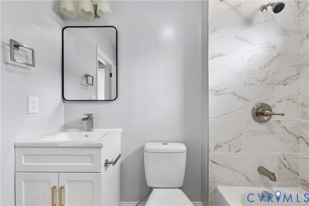 White vanity with gold-tone hardware, rectangular undermount sink, and brushed nickel faucet