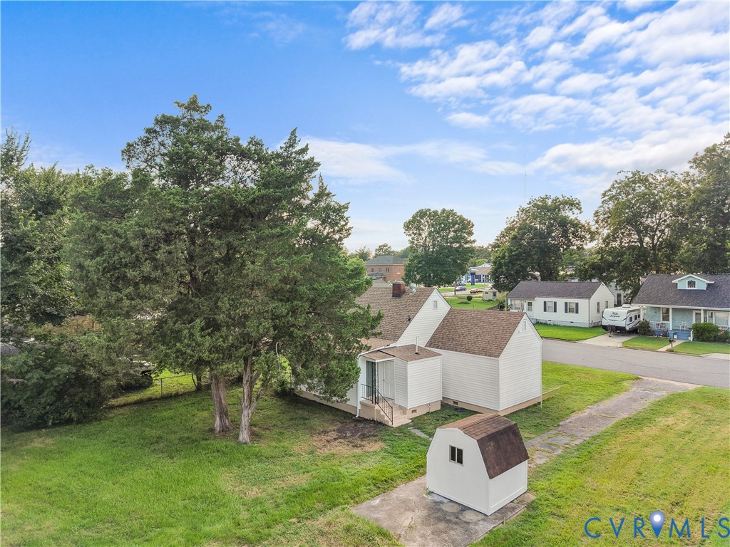 White exterior, screened porch, detached storage shed, paved driveway, mature trees