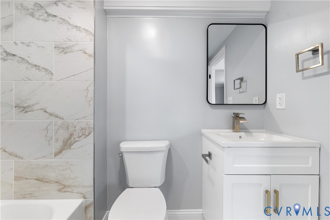 White vanity with golden hardware, rectangular undermount sink, and a modern single-handle faucet