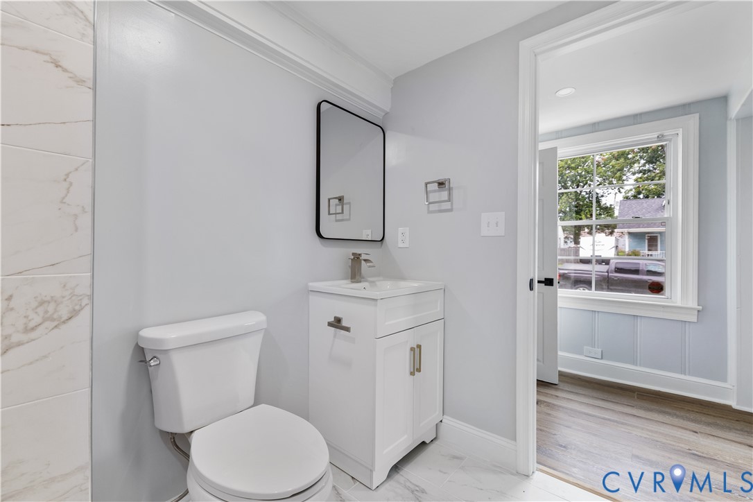 White vanity with a rectangular sink, modern black-framed mirror, and brushed nickel fixtures