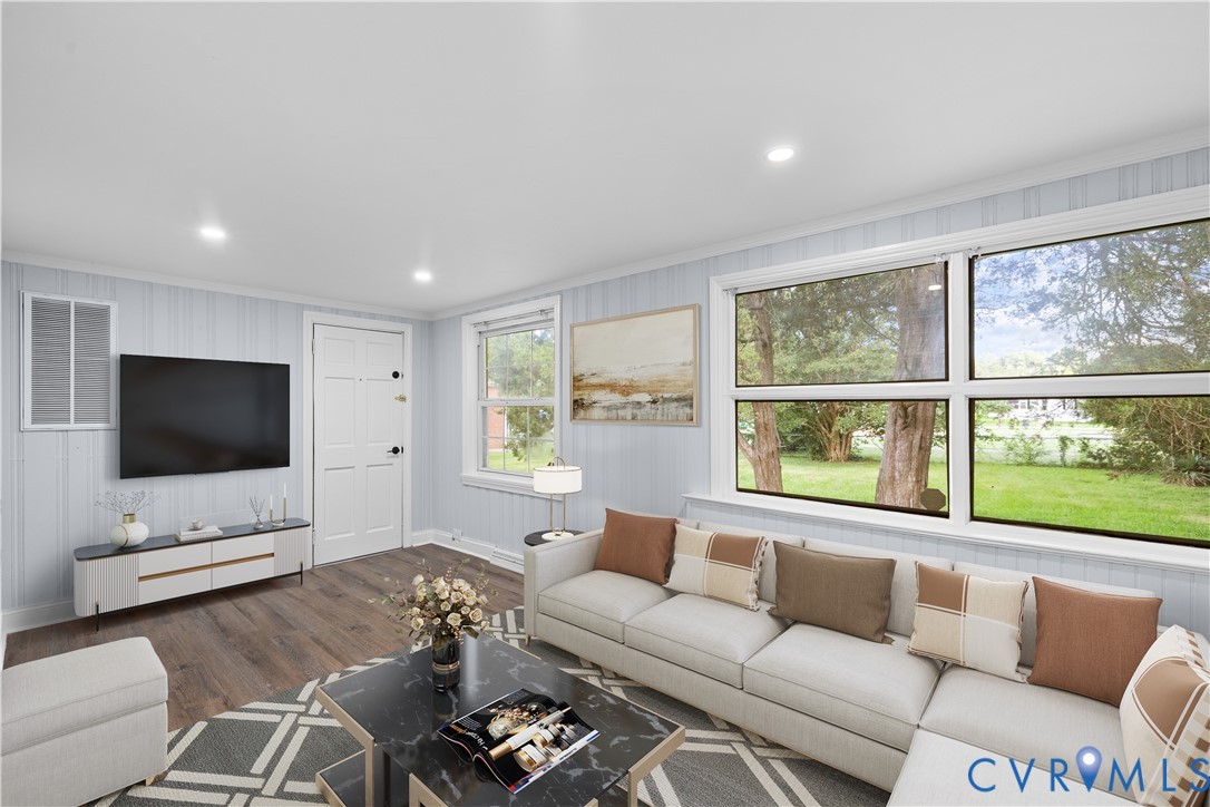 (Virtually-Staged) Spacious living area featuring wood-finish flooring, recessed lighting, and expansive windows