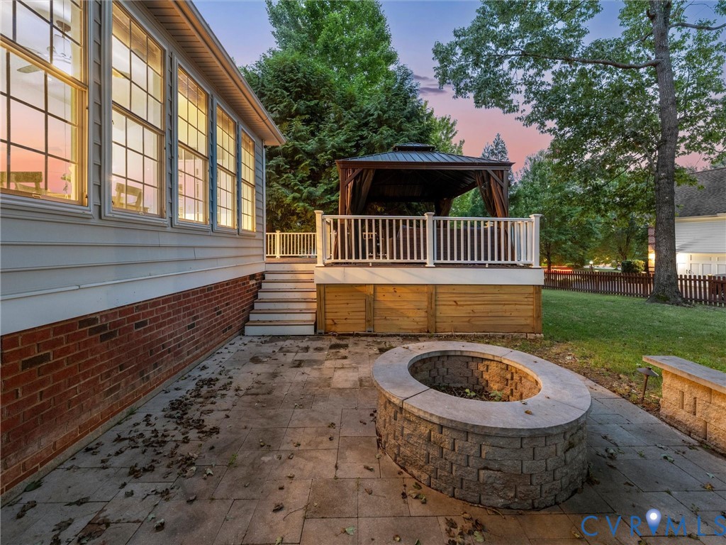 Expansive patio with a paver surface and a built-in stone fire pit