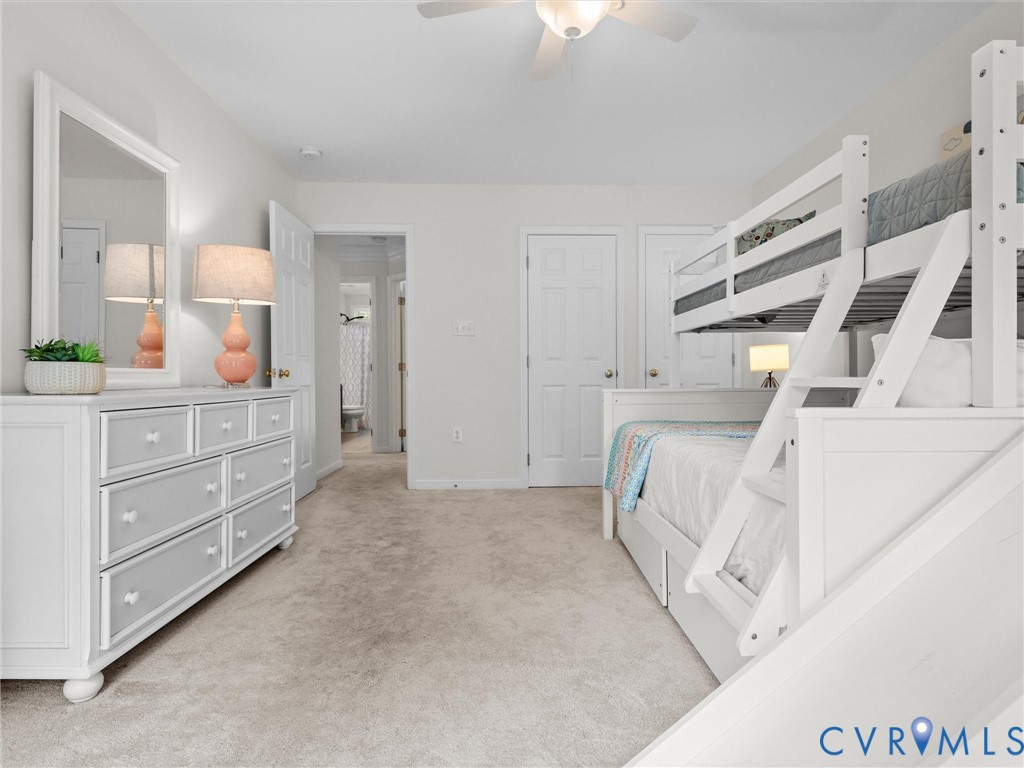 Plush carpet flooring, ceiling fan, and white paneled doors